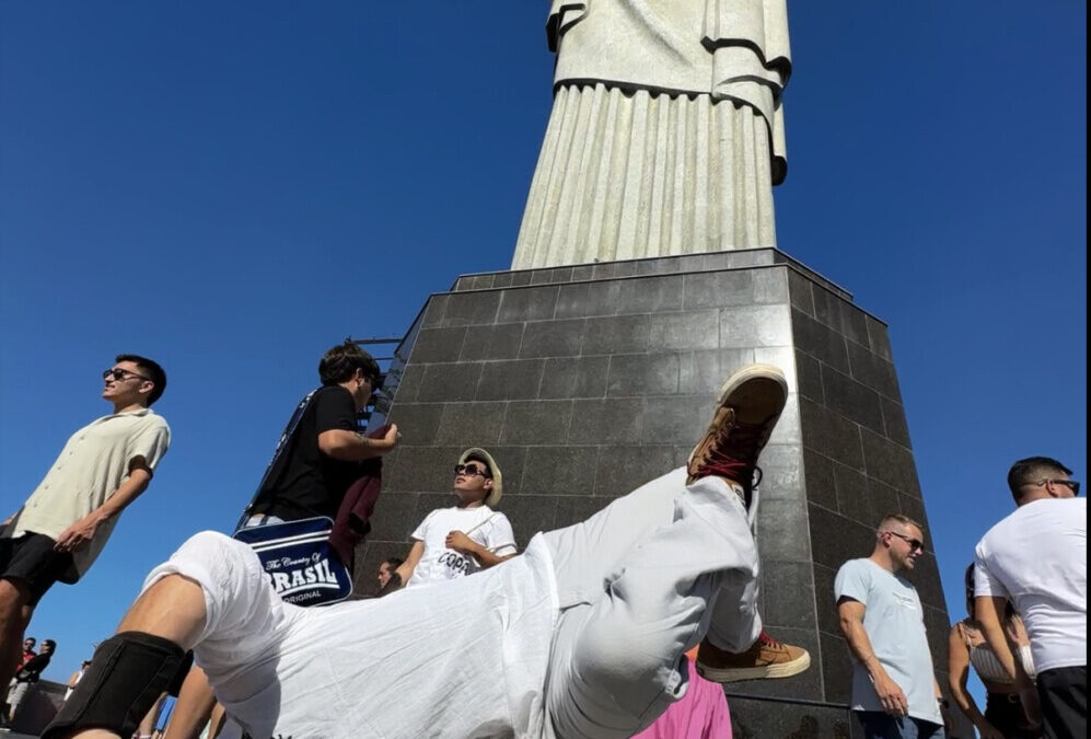 Breakdancer freezing on one hand at the base of Christ the Redeemer statue in Rio de Janeiro, Brazil