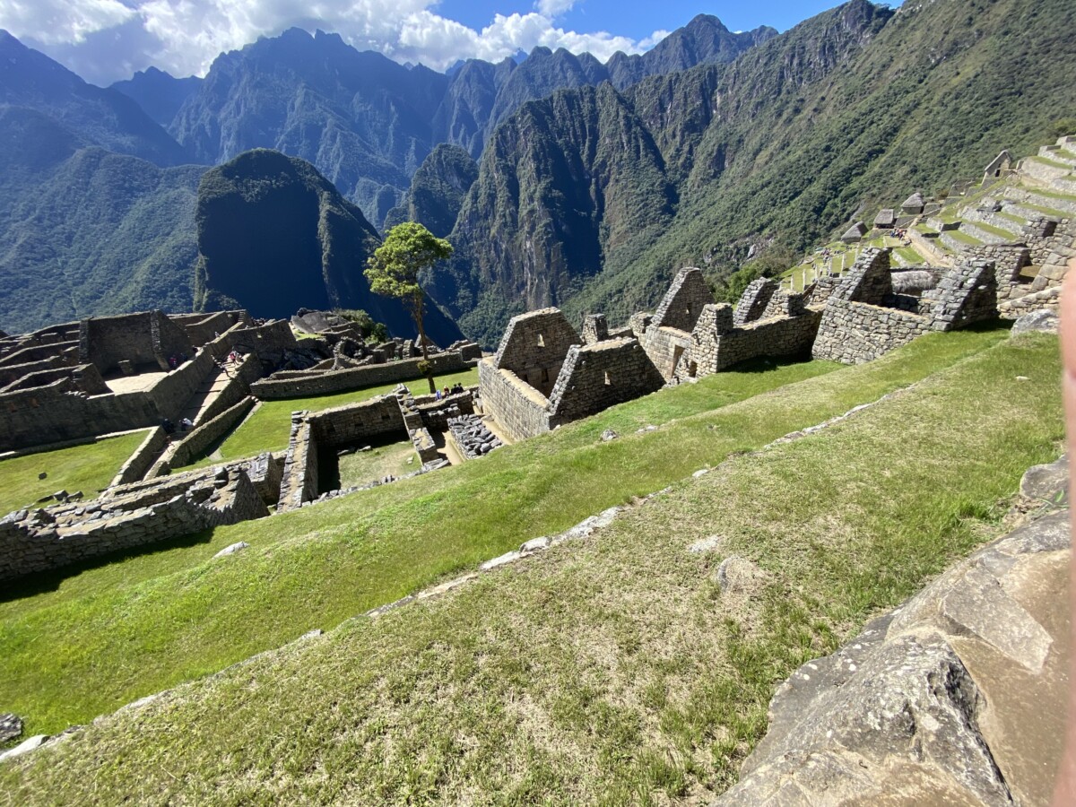 Overlook of Machu Picchu's stone terraces and houses with the Andes and Huayna Picchu in the background under a clear sky